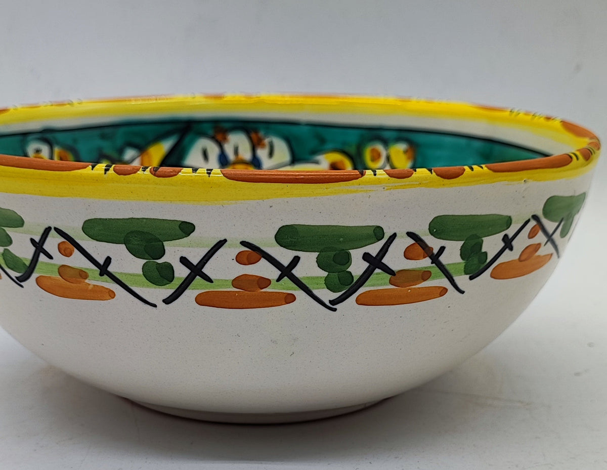 Side view of turquoise and white Caltagirone pottery bowl with green painted motifs