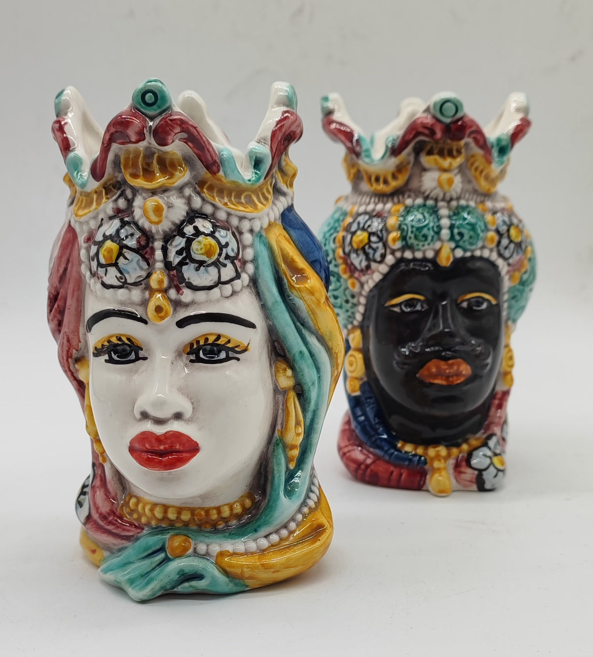 Female ceramic Moorish head with an ivory-colored face, red lips and a decorated floral crown.