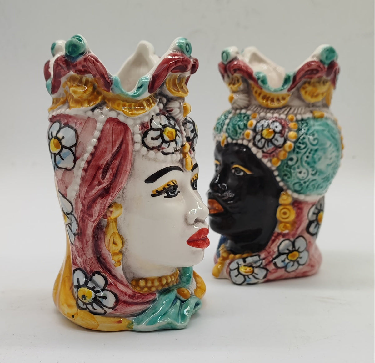 Male ceramic Moorish head with a black glazed face, turquoise headwear and an ornate crown.