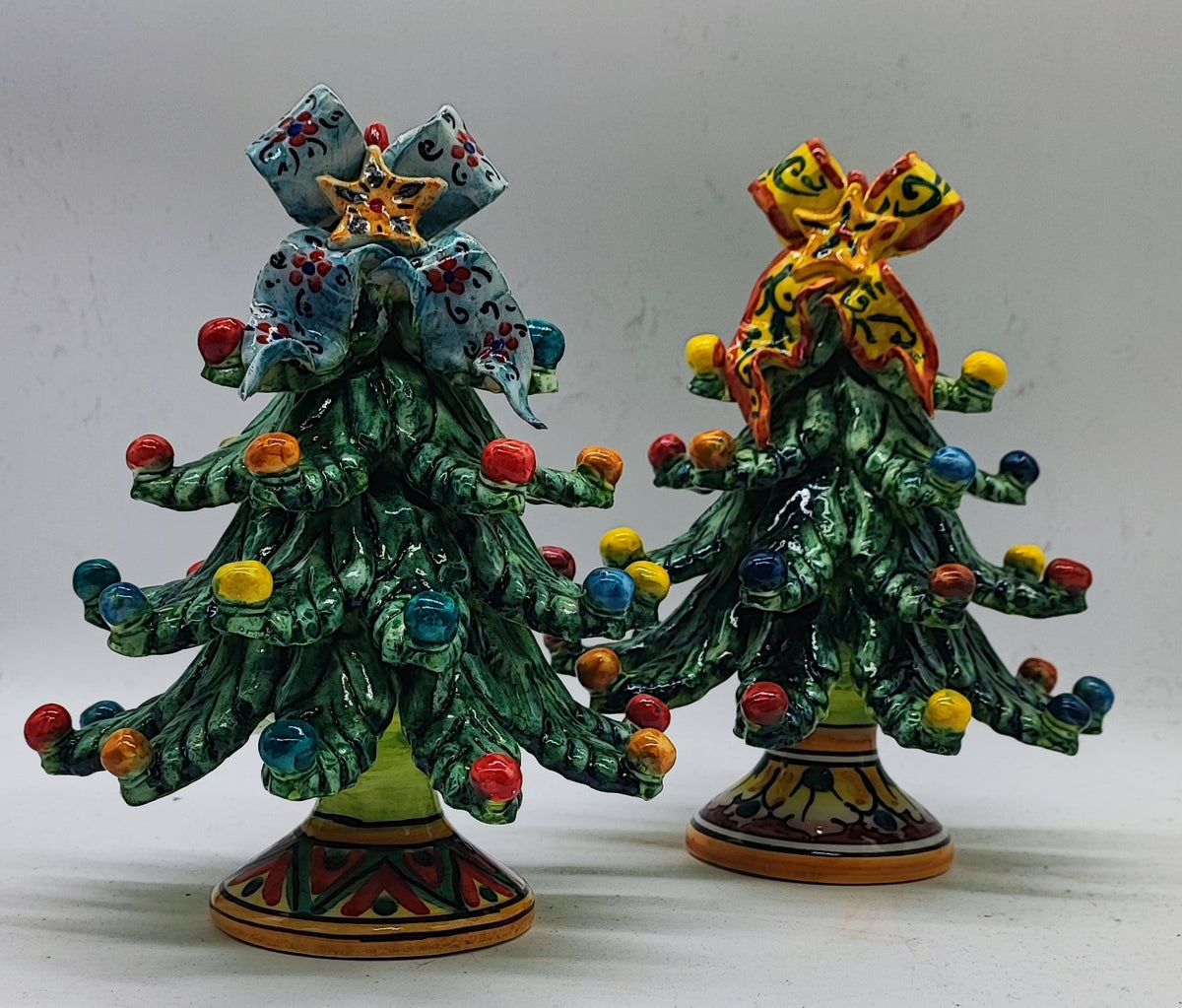 Green Caltagirone ceramic Christmas tree with blue floral bow and multicolored ornaments