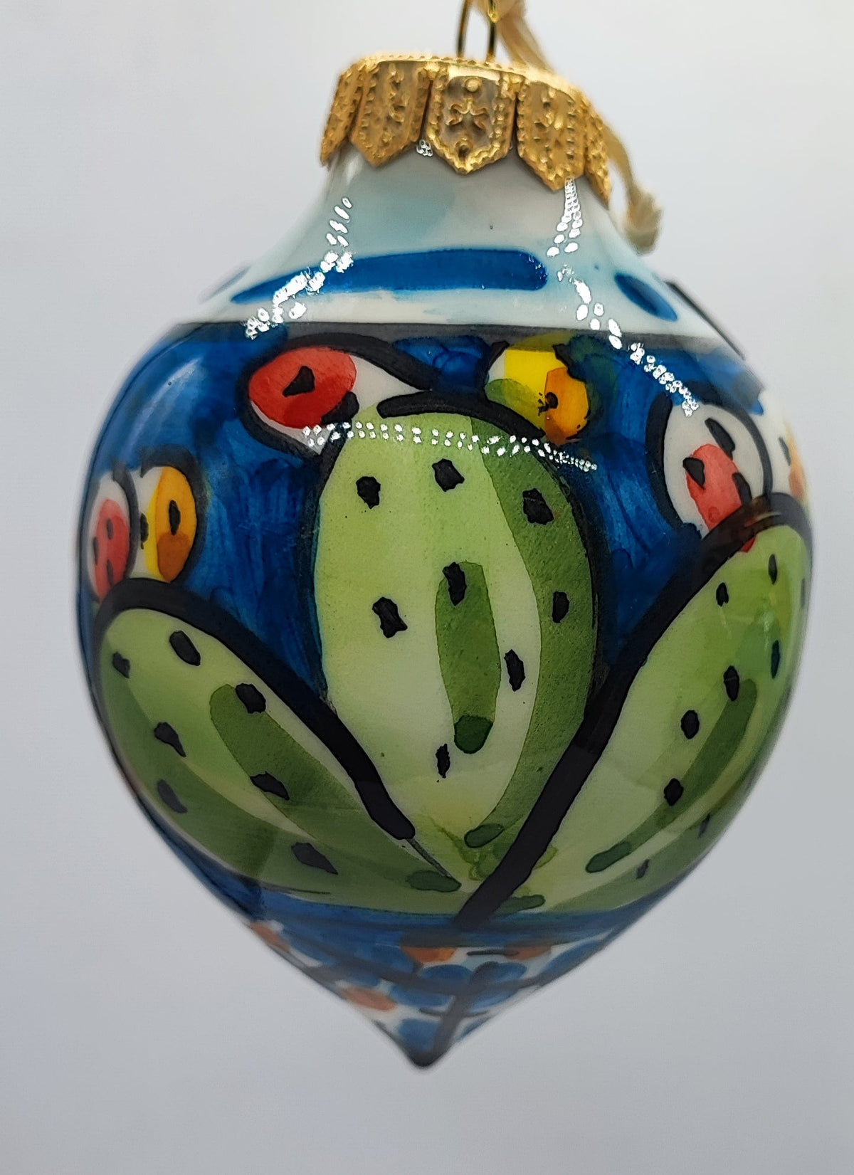 Blue hand-painted Italian ceramic Christmas ornament decorated with traditional Sicilian prickly pear cactus.