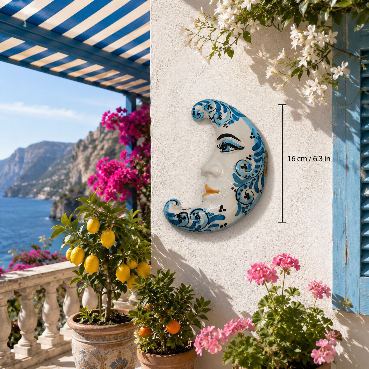 Blue Sicilian ceramic crescent moon measuring 16 cm tall on an Italian terrace with lemons and flowers