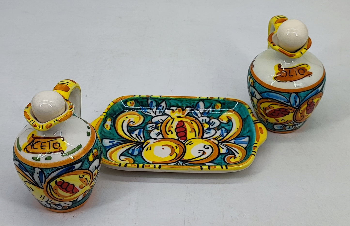 Caltagirone-style ceramic oil and vinegar bottles decorated with colorful Sicilian lemons