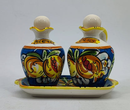 Caltagirone-style ceramic olive oil and vinegar bottles decorated with colorful Mediterranean fruit
