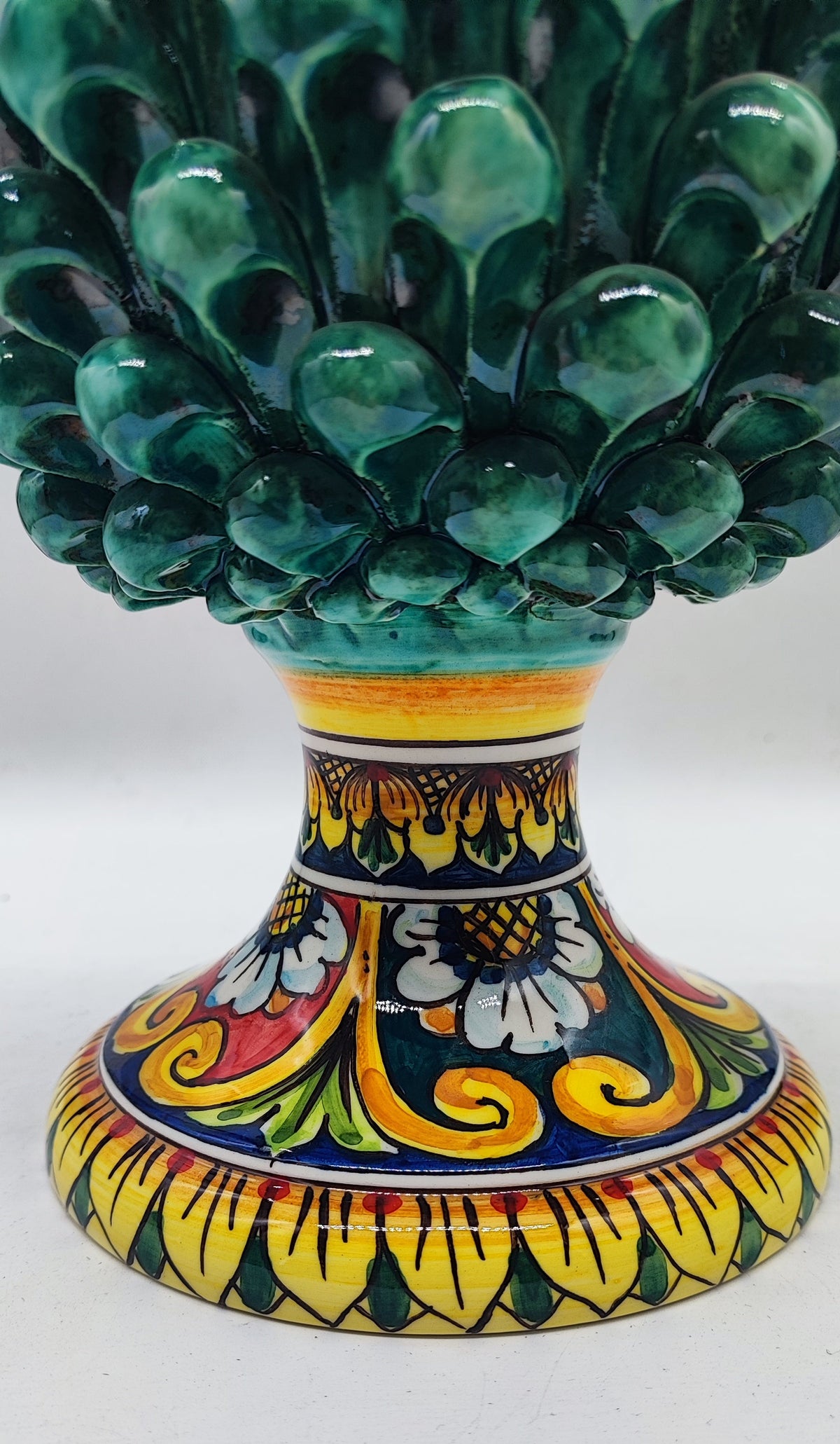 Close-up of the colorful hand-painted Sicilian majolica pedestal featuring yellow, blue, green and red floral patterns.