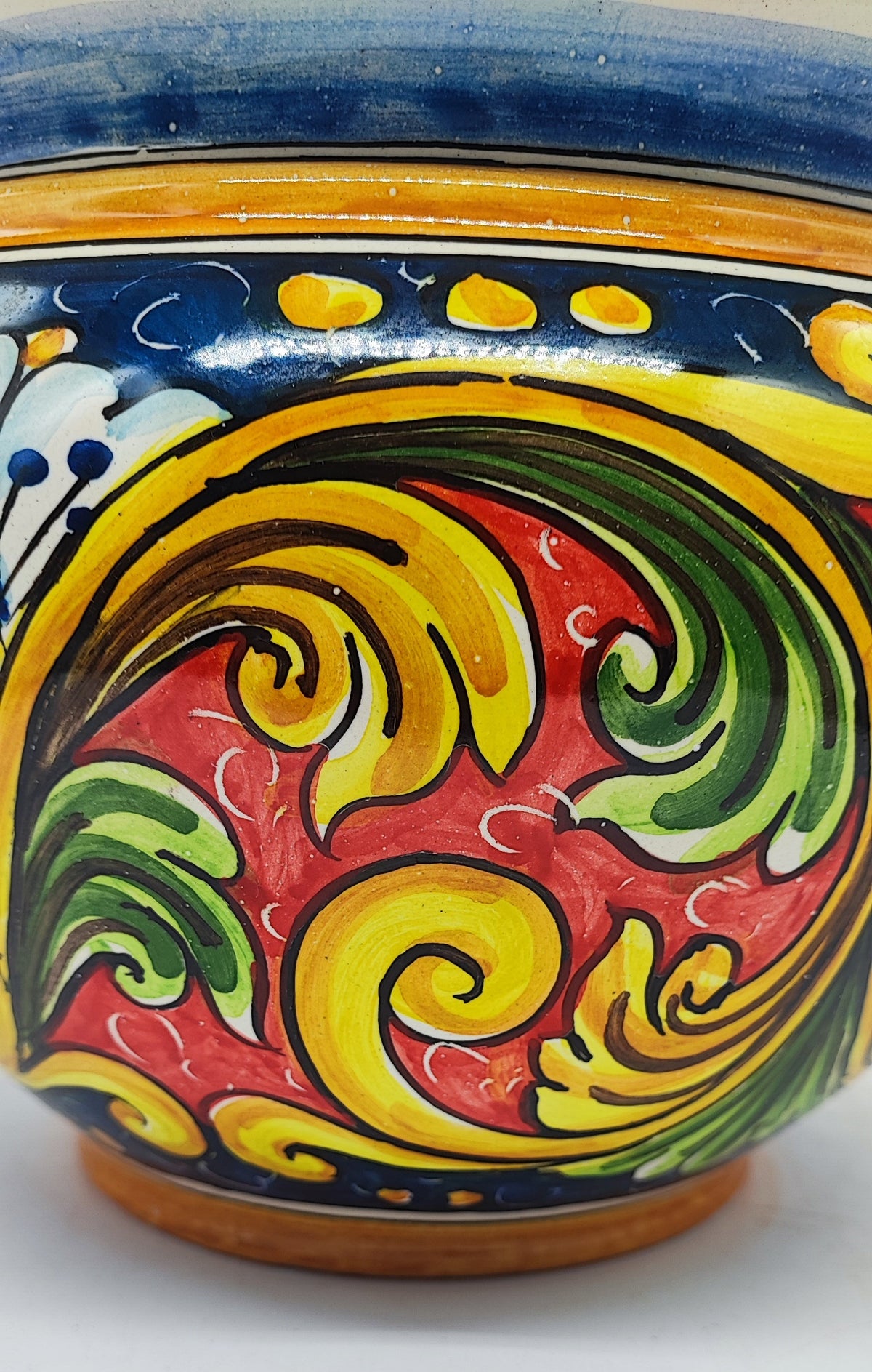 Colorful Italian ceramic planter holding a small lemon tree on a sunny Mediterranean-style terrace.
