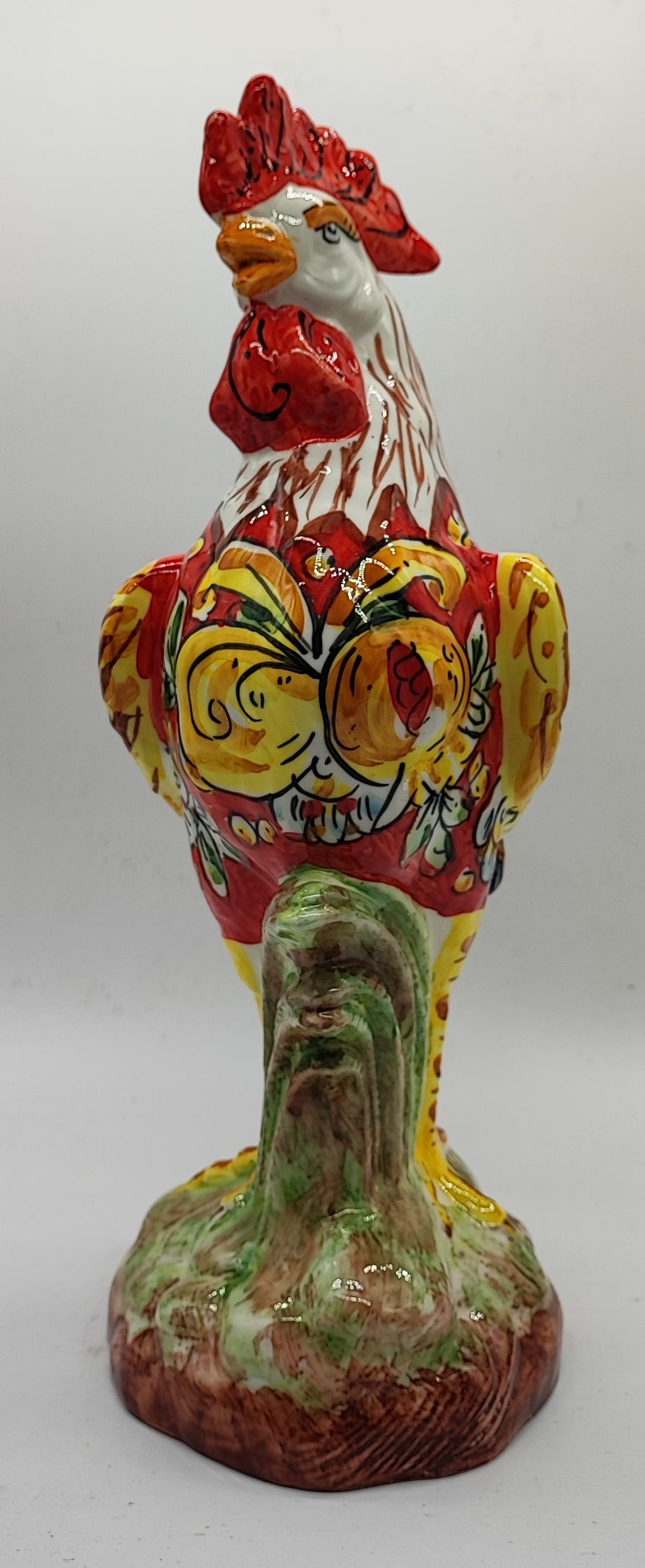Close-up of the ceramic rooster's red comb, yellow beak and hand-painted eye.