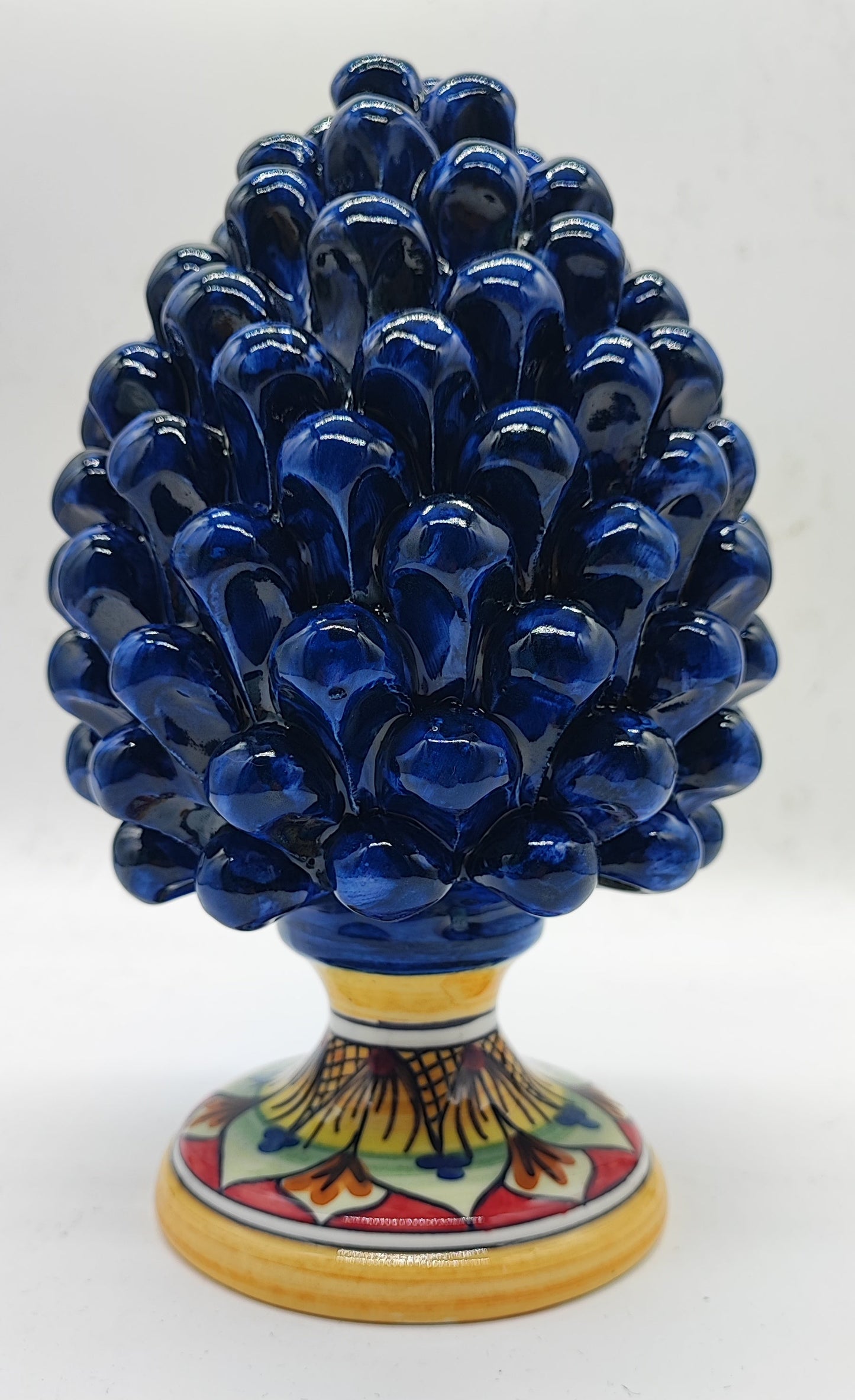 Close-up of a cobalt blue Caltagirone ceramic pigna with glossy glaze and hand-painted base