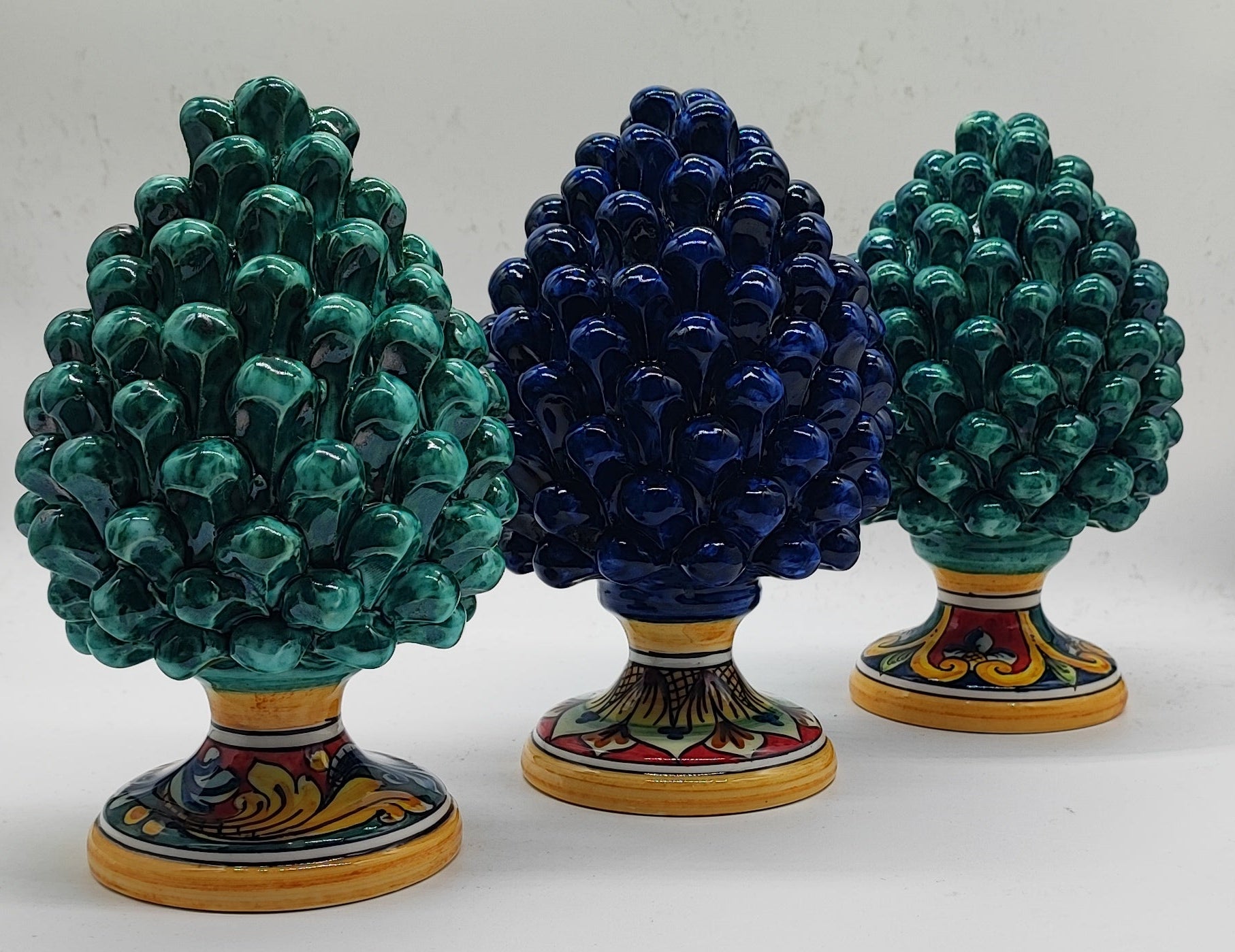 Close-up of an emerald green Caltagirone ceramic pigna with glossy glaze and hand-painted Sicilian base