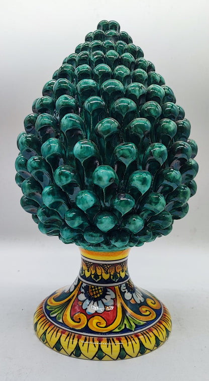 Emerald green Sicilian ceramic pine cone styled with festive greenery and warm Christmas decorations.