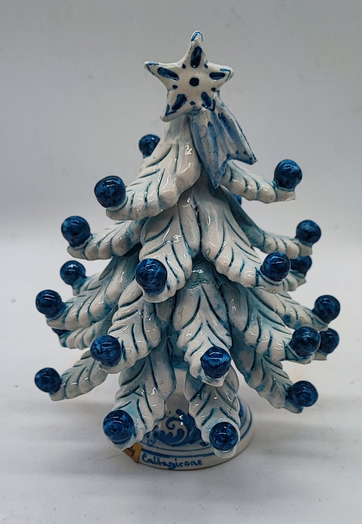 Close-up of hand-painted cobalt blue ornaments and traditional Sicilian decorative details on a ceramic Christmas tree.