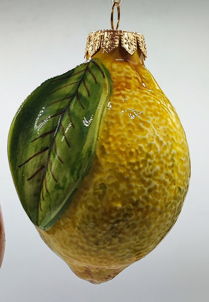 Authentic Italian ceramic lemon Christmas tree ornament with a textured yellow surface and green leaf.