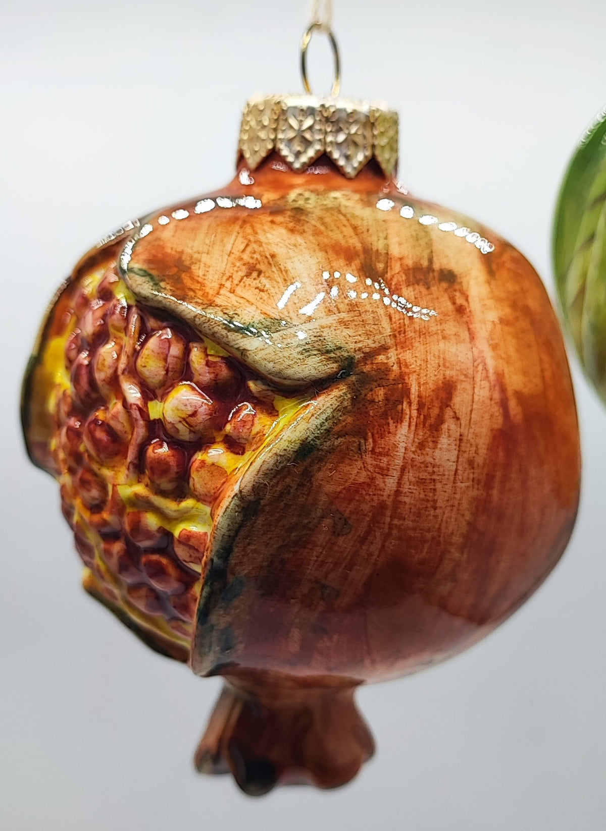 Handmade Italian ceramic pomegranate hanging Christmas ornament with detailed seeds and a glossy terracotta-colored glaze.