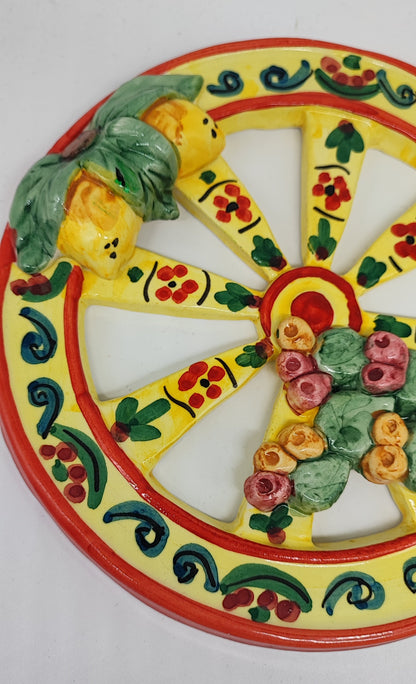 Yellow Sicilian ceramic cart wheel with raised lemons, green leaves and prickly pears, 21 cm in diameter.