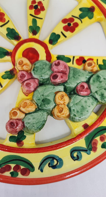 Yellow Sicilian ceramic cart wheel with raised lemons, green leaves and prickly pears, 21 cm in diameter.
