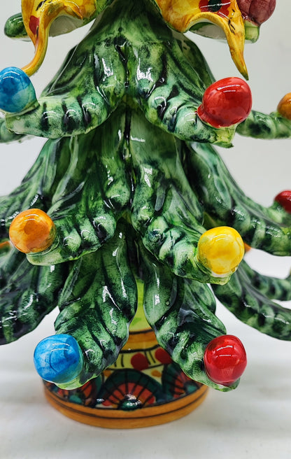 Close-up of colorful glazed ceramic ornaments and hand-painted branches on a Sicilian Christmas tree.