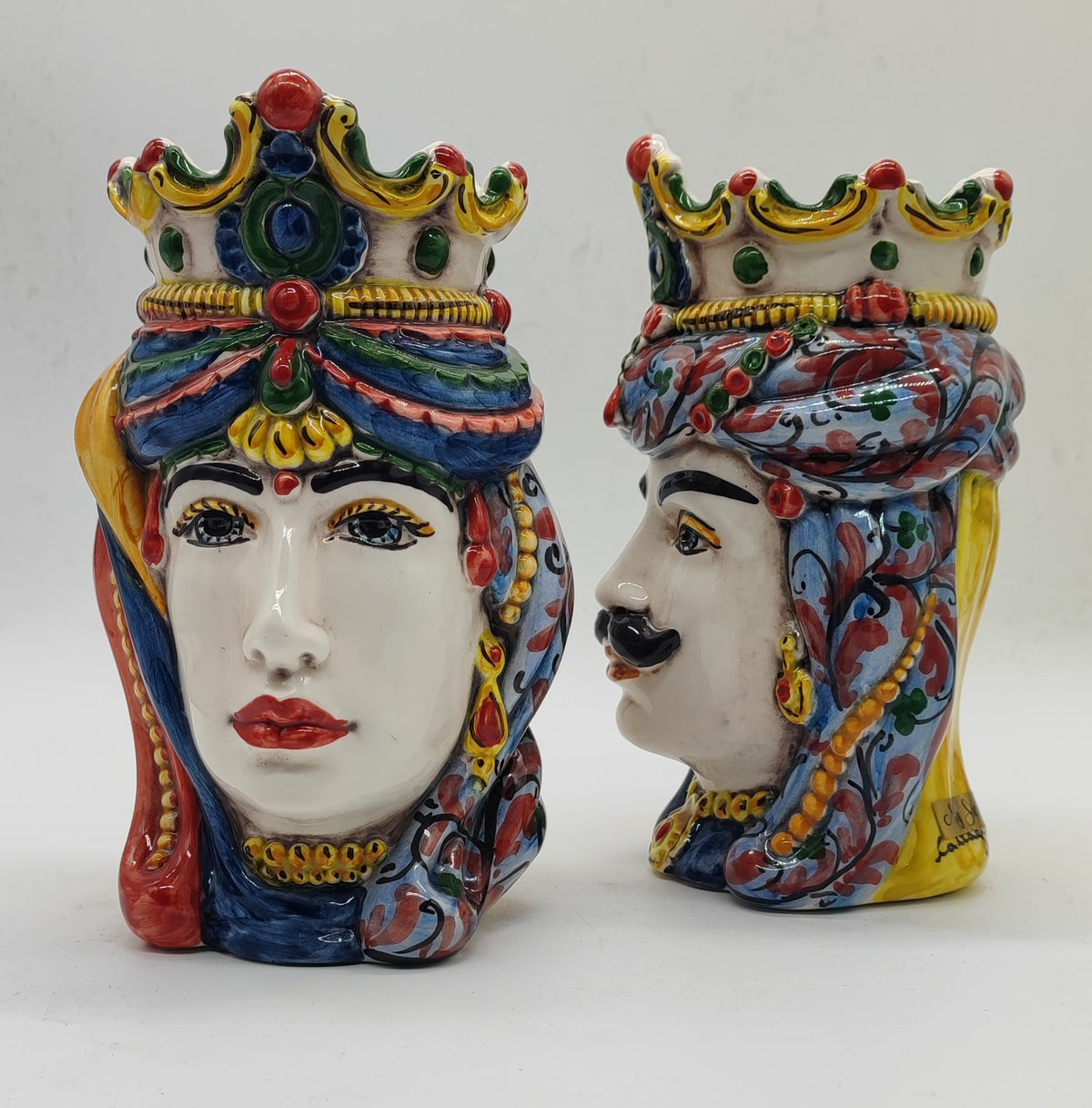 Female Sicilian Moorish Head facing forward beside male ceramic head in profile, showing traditional hand-painted decorations.