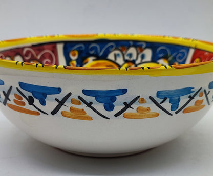 Side view of handmade Sicilian ceramic bowl with blue and yellow painted patterns
