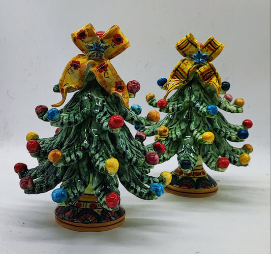 Two traditional Sicilian ceramic Christmas trees showing floral and striped yellow bow designs.