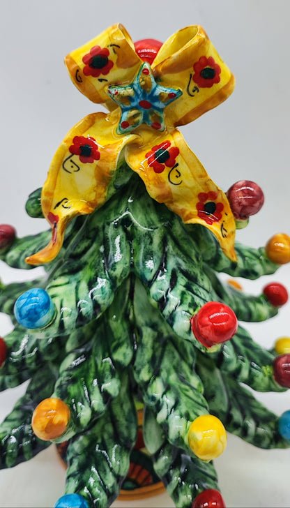 Detailed view of the hand-painted yellow floral bow and blue star on a Sicilian ceramic Christmas tree.