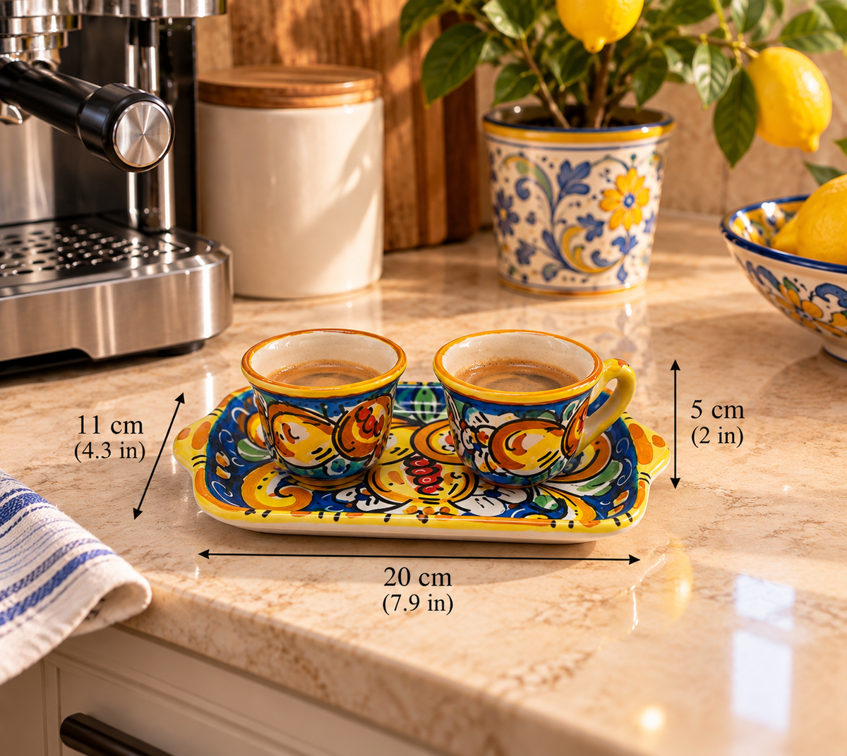 Close-up of a handmade Sicilian ceramic espresso set featuring glossy turquoise glaze, yellow floral patterns and matching colorful coffee cups.
