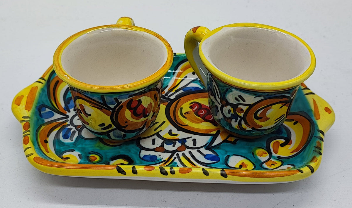 Top view of a traditional Sicilian ceramic espresso set with two colorful cups and matching tray, decorated with turquoise, yellow and orange floral motifs.