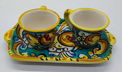 Top view of a traditional Sicilian ceramic espresso set with two colorful cups and matching tray, decorated with turquoise, yellow and orange floral motifs.