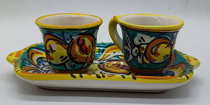 Front view of two hand-painted Sicilian espresso cups on a rectangular ceramic serving tray, featuring traditional Caltagirone majolica decorations.