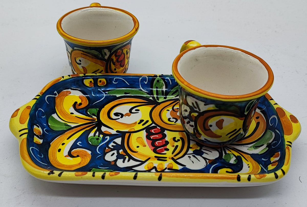 Detailed view of traditional Sicilian majolica espresso cups and ceramic tray, featuring vibrant yellow, blue, green and orange hand-painted decorations.