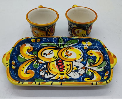 Detailed view of traditional Sicilian majolica espresso cups and ceramic tray, featuring vibrant yellow, blue, green and orange hand-painted decorations.