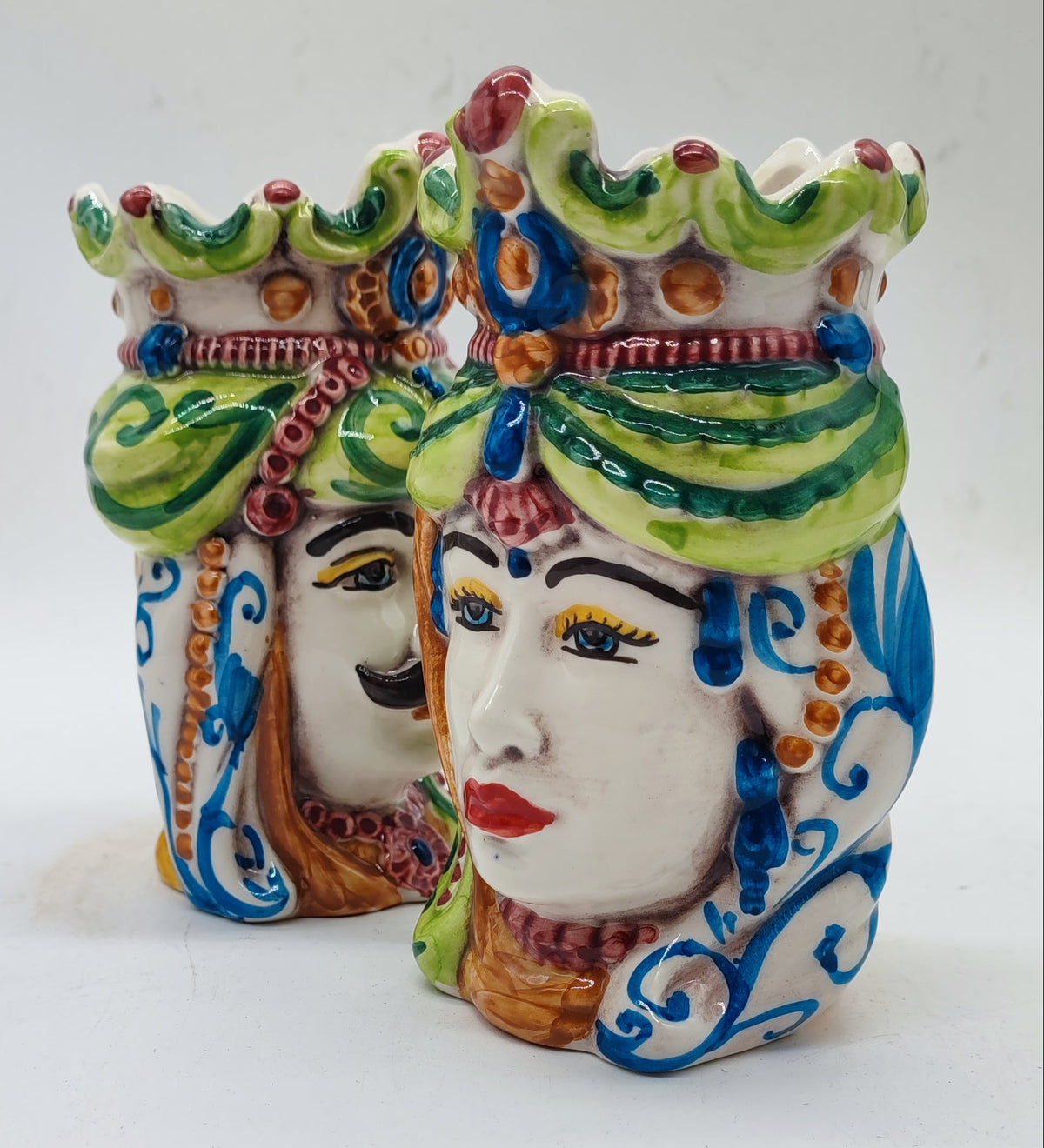 Traditional Sicilian Teste di Moro king and queen pottery shown from an angled side view with detailed painted decorations.