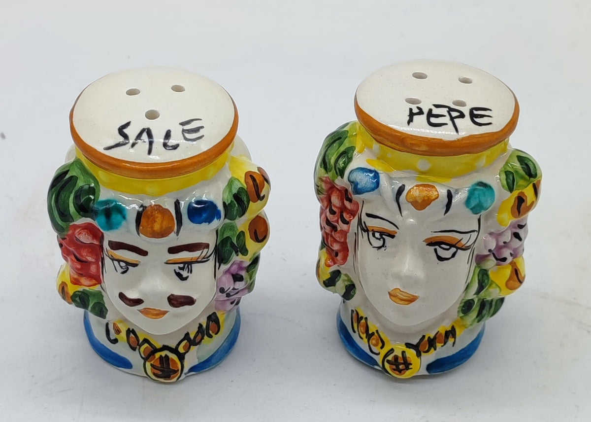 Overhead view of a pair of handmade Sicilian ceramic salt and pepper shakers on a white background.