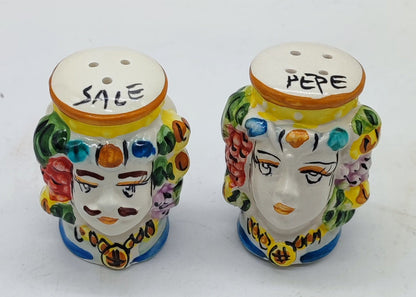 Overhead view of a pair of handmade Sicilian ceramic salt and pepper shakers on a white background.