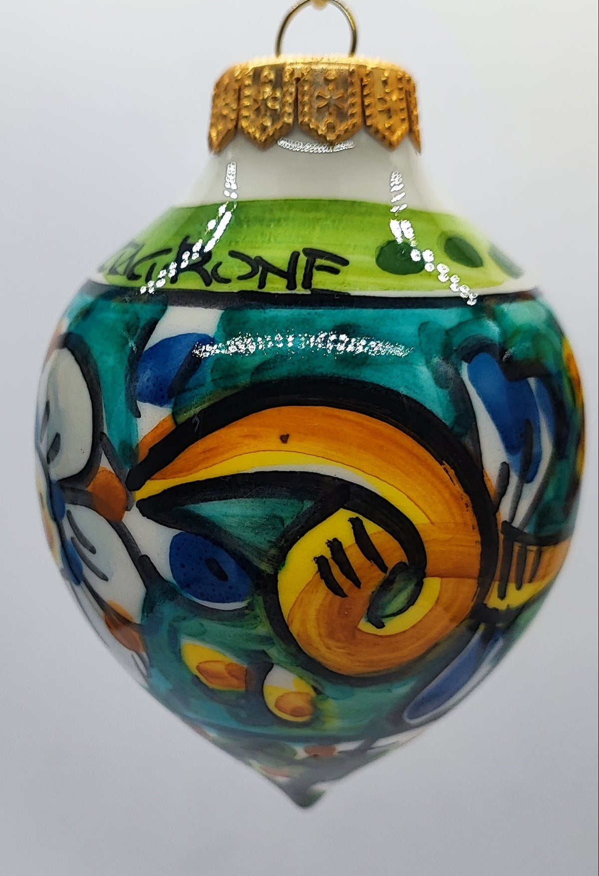 Hand-painted turquoise and green Sicilian ceramic Christmas bauble featuring traditional Mediterranean floral decoration.